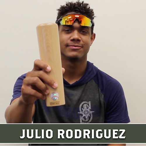 Julio Rodriguez holding up a wooden Dugout Mugs baseball bat mug.