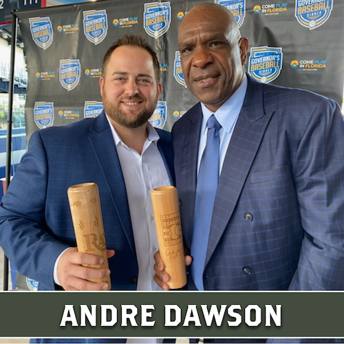 Andre Dawson posing beside another man, both holding wooden Dugout Mugs baseball bat mugs.
